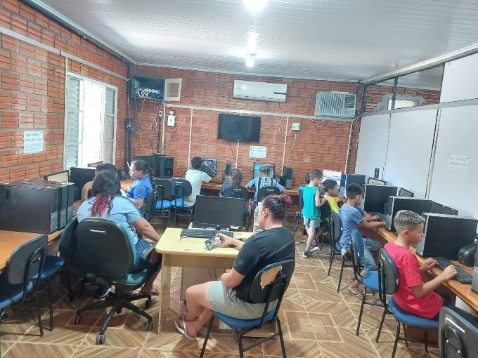 Adolescentes usando computadores no laboratório de informática