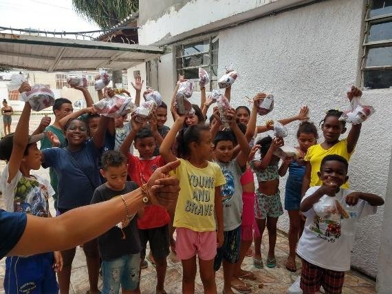 Crianças ao ar livre comemorando a Páscoa com as mãos erguidas